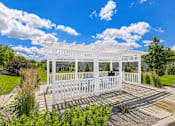 Thumbnail 3 of 24 - A white wooden structure with a porch and a white picket fence.