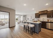 Thumbnail 19 of 24 - A modern kitchen with a bar stool in front of it.