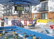 Thumbnail 13 of 26 - Outdoor courtyard with colorful seating and games at Hello Apartments, Minneapolis, MN 55427