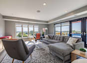 Thumbnail 7 of 26 - Modern living room with sectional sofa and pool access at Hello Apartments, Minneapolis, MN