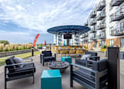 Thumbnail 1 of 26 - Rooftop terrace with firepit and outdoor seating at Hello Apartments, Minneapolis