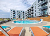 Thumbnail 2 of 26 - Rooftop pool deck with lounge seating and balconies at Hello Apartments, Minnesota