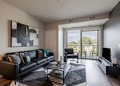 Thumbnail 19 of 26 - Modern living room with balcony and greenspace views at Hello Apartments, Minnesota