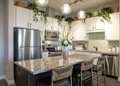 Thumbnail 22 of 26 - Kitchen with island seating and stainless appliances at Hello Apartments, Minneapolis, Minnesota