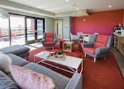Thumbnail 9 of 26 - Resident lounge with colorful accent wall and outdoor terrace at Hello Apartments, Minnesota, 55427