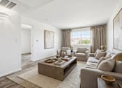 Thumbnail 4 of 10 - A modern living room with a grey sofa, a wooden coffee table, and a large painting on the wall.