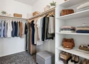Thumbnail 7 of 10 - A well-organized closet with clothes and shoes neatly arranged on shelves and hangers.
