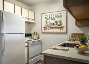 Thumbnail 9 of 10 - A kitchen with a refrigerator, oven, and sink.