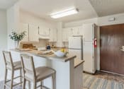 Thumbnail 8 of 12 - A kitchen with white cabinets and a wooden door.
