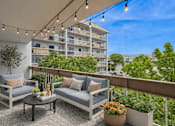 Thumbnail 5 of 12 - A balcony with a table and two chairs is decorated with string lights.