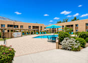 Thumbnail 11 of 23 - A pool area with a blue umbrella and chairs.