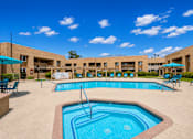Thumbnail 12 of 23 - A large outdoor swimming pool with a fountain in the middle.