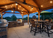 Thumbnail 6 of 25 - A wooden patio with a table and chairs under a roof at Aster Meadow, Vadnais Heights, MN, 55127
