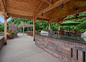 Thumbnail 4 of 25 - A patio with a wooden roof and a brick wall at Aster Meadow, Vadnais Heights, MN, 55127