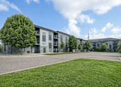 Thumbnail 2 of 25 - Apartment complex with a green lawn in front at Aster Meadow, Vadnais Heights, MN, 55127