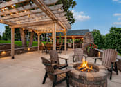 Thumbnail 7 of 25 - A patio with a fire pit and chairs under a pergola at Aster Meadow, Vadnais Heights, MN, 55127