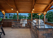 Thumbnail 5 of 25 - A covered outdoor kitchen area with a grill and oven at Aster Meadow, Vadnais Heights, MN, 55127