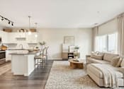 Thumbnail 12 of 25 - A modern kitchen with white appliances and a dining area with a white couch at Aster Meadow, Vadnais Heights, MN, 55127