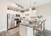 Thumbnail 17 of 25 - A modern kitchen with a stainless steel refrigerator and wooden flooring at Aster Meadow, Vadnais Heights, MN, 55127
