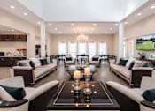 Thumbnail 2 of 25 - A modern living room with a large TV and a fireplace.