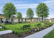 Thumbnail 8 of 25 - A row of houses with a sidewalk and benches in front.