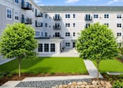 Thumbnail 1 of 41 - Courtyard with green lawn and landscaping at The Hendrickson Apartments, Falcon Heights