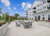 Thumbnail 5 of 41 - Outdoor terrace with lounge seating and planters at The Hendrickson Apartments, Minnesota