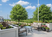 Thumbnail 14 of 41 - Outdoor patio seating area with garden planters at The Hendrickson Apartments, Falcon Heights, MN 55113