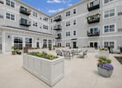 Thumbnail 2 of 41 - Interior courtyard with seating area and planter boxes at The Hendrickson Apartments, Falcon Heights, MN