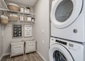 Thumbnail 34 of 41 - Stacked washer and dryer with organized storage at The Hendrickson Apartments, Falcon Heights, 55113