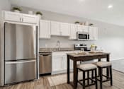 Thumbnail 28 of 41 - Kitchen with granite island and stainless appliances at The Hendrickson Apartments, Minnesota, 55113