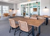 Thumbnail 15 of 41 - Covered patio with dining tables and pendant lights at The Hendrickson Apartments, Falcon Heights