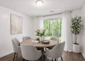 Thumbnail 12 of 14 - A dining room with a round table and grey chairs.