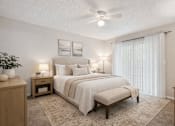 Thumbnail 14 of 14 - A bedroom with a large bed and a ceiling fan.