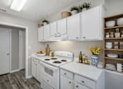 Thumbnail 8 of 16 - A kitchen with white cabinets and a white stove top oven.