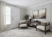 Thumbnail 11 of 16 - A living room with a white door, two chairs, a table, and two pictures on the wall.