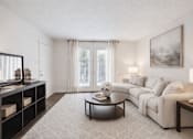 Thumbnail 7 of 15 - A living room with a white couch, a coffee table, and a painting on the wall at Emerald Pointe, Riverdale, GA