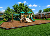 Thumbnail 6 of 17 - A playground with a green slide and a wooden swing set.