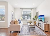 Thumbnail 17 of 25 - Bright living room with patterned area rug at Connect at First Creek Apartments, Colorado