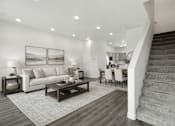 Thumbnail 5 of 16 - A living room with a staircase leading to the upper floor.