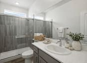 Thumbnail 15 of 16 - A bathroom with a white toilet, a white sink, and a glass shower stall.