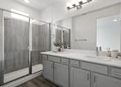 Thumbnail 14 of 16 - A bathroom with a walk-in shower and double sinks.