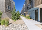 Thumbnail 2 of 16 - A row of modern houses with a gravel pathway in between.