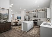Thumbnail 6 of 16 - A kitchen with a dining table and chairs in the middle of the room.