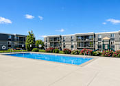 Thumbnail 1 of 26 - Swimming pool with surrounding deck and playground at Park Station Apartments, Midvale, 84047