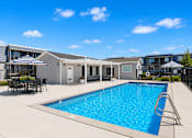 Thumbnail 7 of 26 - Outdoor swimming pool with patio seating area at Park Station Apartments, Midvale, UT