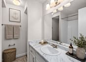 Thumbnail 23 of 26 - Bathroom vanity with marble countertop and mirror at Park Station Apartments, Midvale, Utah