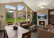 Thumbnail 1 of 23 - A living room with a fireplace and a view of a lake.