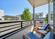 Thumbnail 16 of 39 - Private balcony with seating and courtyard views at Sequel Homes Apartments, Englewood, CO 80110
