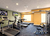 Thumbnail 7 of 18 - Fitness center with cardio equipment and tvs at Cypress Court Apartments, St Cloud, MN